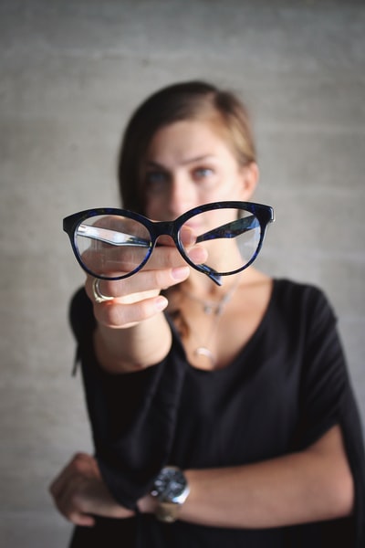 选择性焦点眼镜坚持女人的照片
